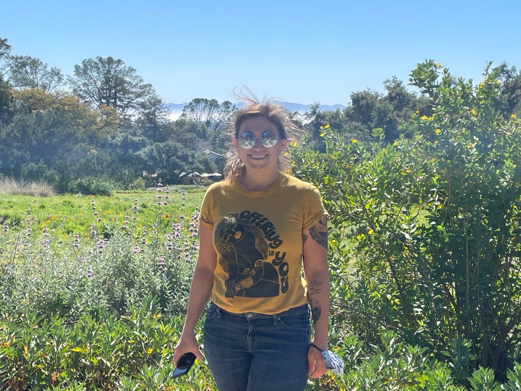 Alyssa standing in a field of plants.