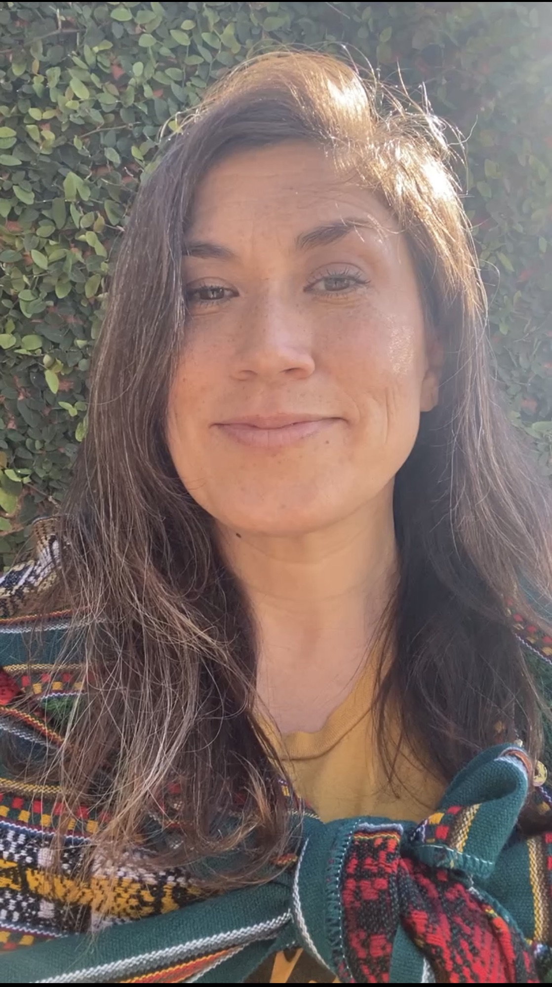 Alyssa smiling at the camera, wrapped in a manta from Cuzco.